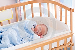 Newborn baby boy in hospital cot