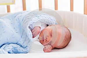 Newborn baby boy in hospital cot