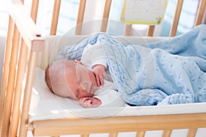 Newborn baby boy in hospital cot