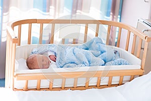 Newborn baby boy in hospital cot