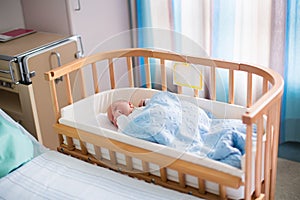 Newborn baby boy in hospital cot