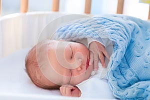 Newborn baby boy in hospital cot