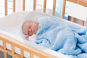 Newborn baby boy in hospital cot