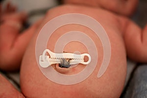 Newborn baby boy laying on the bed with umbilical cord clamp