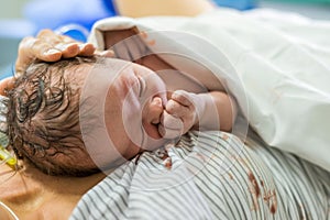 Newborn baby boy laying down on the chest of his mom