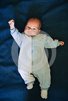 Newborn baby boy lying on blue cloth