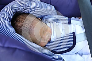 Newborn baby boy in safety car seat