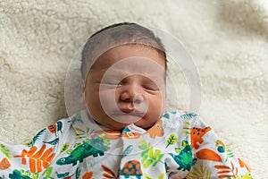 Newborn baby boy sleep in his bed on a white blanket