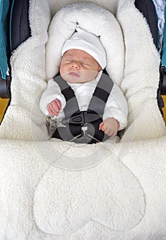 Newborn baby boy sleeping in comfortable car seat