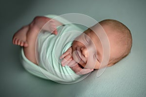 Newborn baby boy sleeping confort pose on a beanbag