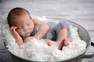 Newborn baby boy, sleeping peacefully in basket, dressed in knit