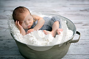 Newborn baby boy, sleeping peacefully in basket, dressed in knit