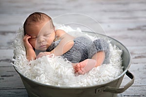 Newborn baby boy, sleeping peacefully in basket, dressed in knit