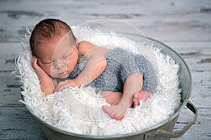 Newborn baby boy, sleeping peacefully in basket, dressed in knit