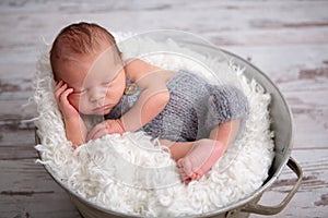 Newborn baby boy, sleeping peacefully in basket, dressed in knit