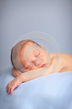 Newborn Baby Boy Sleeping Peacefully on Blue Blanket