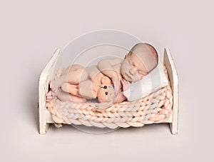 Newborn baby boy sleeping on a small bed