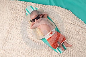 Newborn Baby Boy Sleeping on a Surfboard