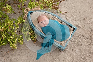 Newborn Baby Boy Sleeping in a Tiny Boat