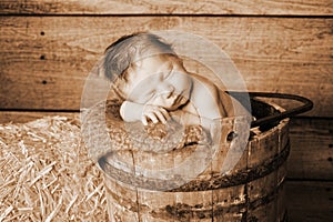Newborn Baby Boy Sleeping in a Vintage Wooden Buck