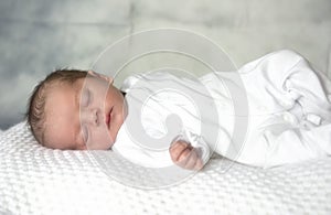 Newborn baby boy sleeping on white blanket