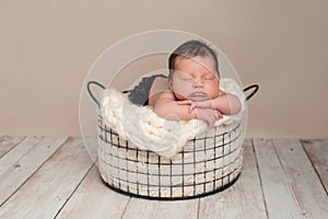 Newborn Baby Boy Sleeping in a Wire Basket
