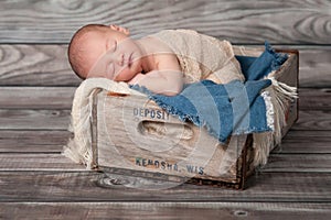 Newborn Baby Boy Sleeping in a Wooden Crate