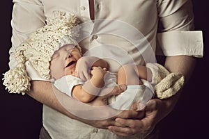 Newborn baby boy smiling in woolen hat, sleeping