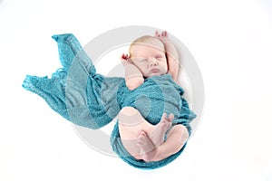 Newborn baby boy in turquoise wrap against white