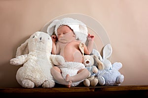 Newborn baby boy wearing a brown knitted rabbit hat and pants, s