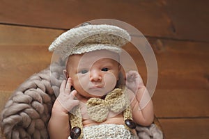 Newborn Baby Boy Wearing a Newsboy Cap and Bowtie