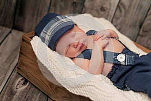 Newborn Baby Boy Wearing a Newsboy Cap and Suspenders photo