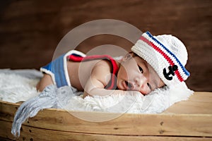 newborn baby boy wearing a white and blue sailor hat