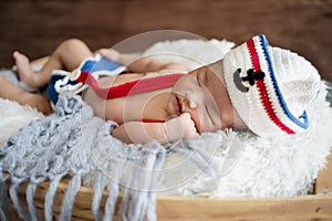 newborn baby boy wearing a white and blue sailor hat