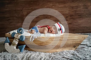 newborn baby boy wearing a white and blue sailor hat