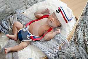 newborn baby boy wearing a white and blue sailor hat