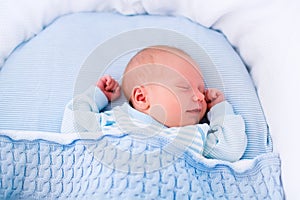 Newborn baby boy in white bassinet