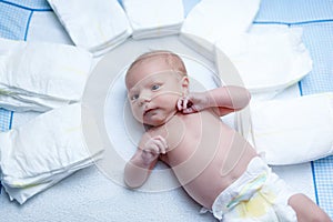 Newborn baby on changing table with diapers