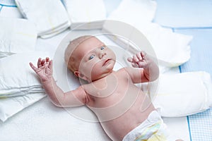 Newborn baby on changing table with diapers