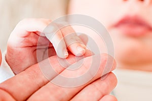 Newborn baby, closeup of fingers of fingers on hand of mother