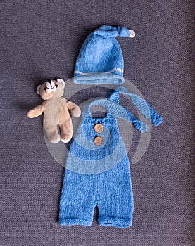 Newborn baby clothes blue color with a small teddy bear.