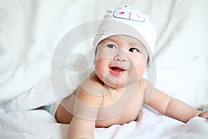 Newborn Baby with Cow Hat Lying Down on a White Blanket