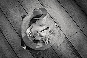 Newborn Baby Cowboy Playing a Tiny Guitar