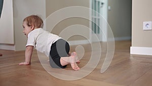 newborn baby crawls. happy family a kindergarten concept. First steps, crawling baby, view from the back. baby learns to