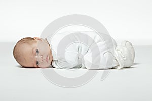 Newborn baby curled up lying