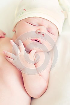 Newborn baby curled up sleeping on a blanket