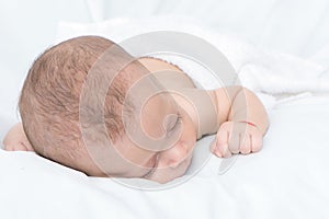 Newborn baby curled up sleeping on a blanket