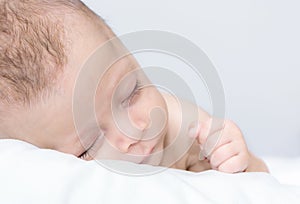 Newborn baby curled up sleeping on a blanket
