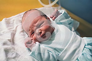 Newborn baby after delivery. Doctor and midwife examining newborn boy after birth in hospital