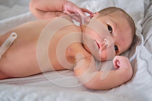 A newborn baby in a diaper is lying naked on the bed. Child boy in a cocoon on a cot